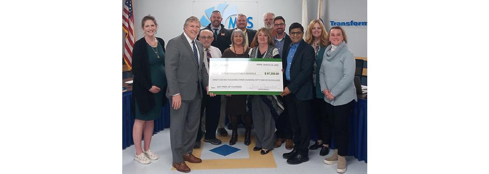 group of people holding up a large check