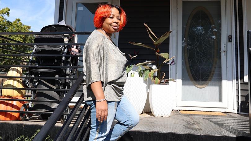 As part of a $3 million grant from Wells Fargo, the nonprofit Elevate helped Chicago-homeowner Katherine Parks make her home more energy efficient to save money while reducing carbon emissions Women stands in front of her home in Chicago