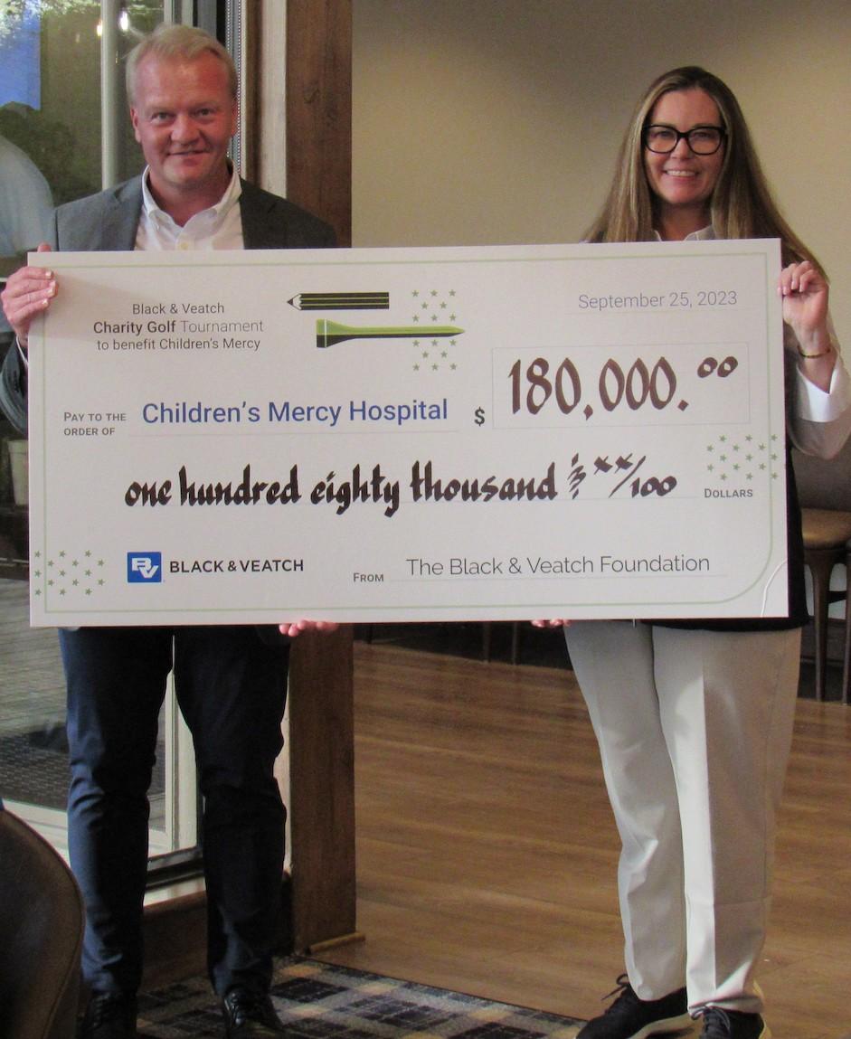 Dr. Tomi Pastinen, director of the Genomic Medical Center at Children’s Mercy Hospital, accepts a $180,000 Black & Veatch contribution from Katie Werner, Black & Veatch chief of staff, on Monday, Sept. 25, 2023. Those proceeds from the company’s charity golf tournament in Olathe, Kansas, brings to more than $5 million the amount Black & Veatch has contributed to Children’s Mercy over the past 27 years. 