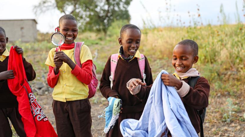 Children smiling while holding different objects