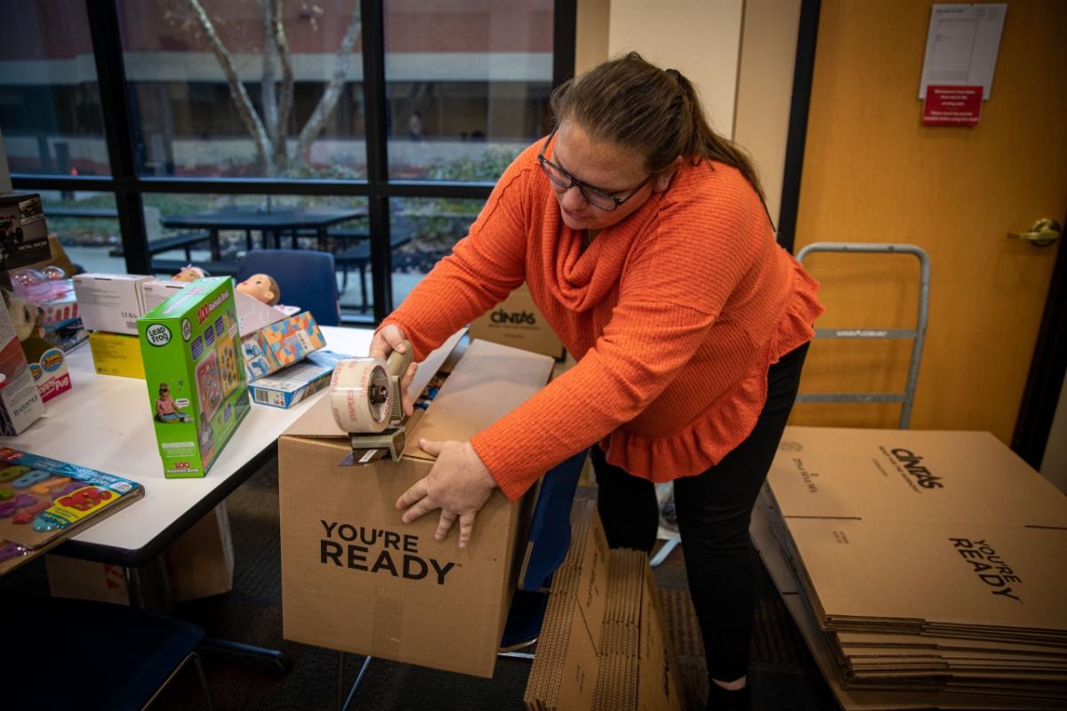 woman taping up a box