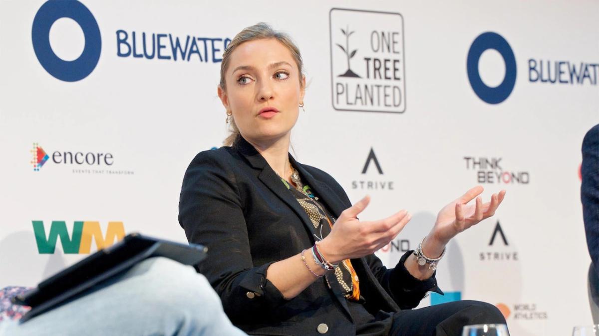 Claire Poole seated on stage, speaking to the others