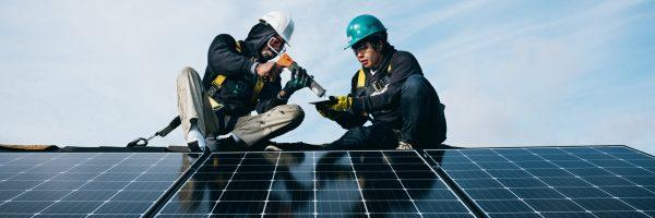 2 people installing a solar panel