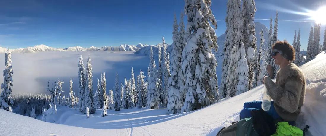 Cole Sibbald sitting on the side of a mountain with freshly fallen snow.