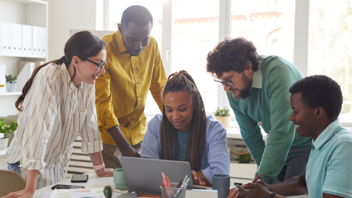 Volunteers collaborating around a computer 