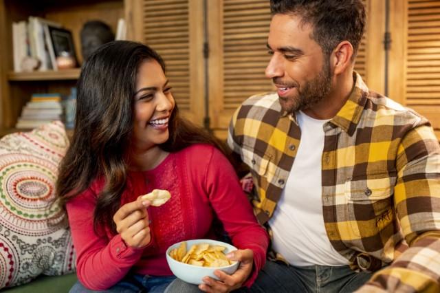 couple snacking on a couch