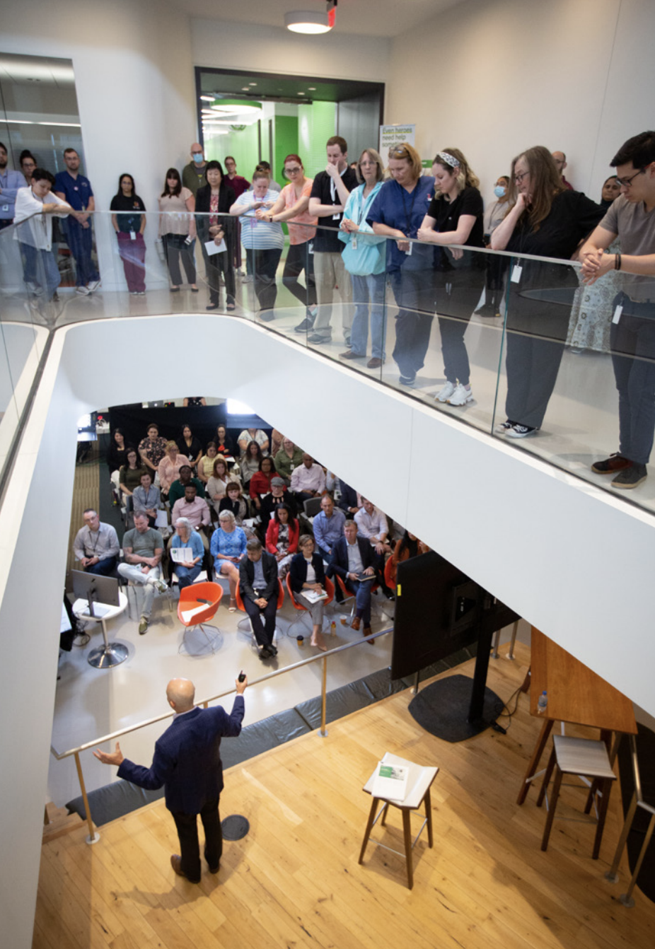 Group of people watching a person give a talk 