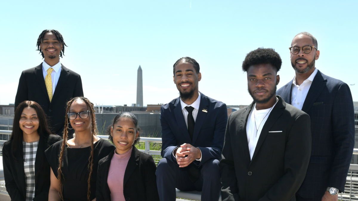 The Scholars posed outside. The Washington Monument in the distance.