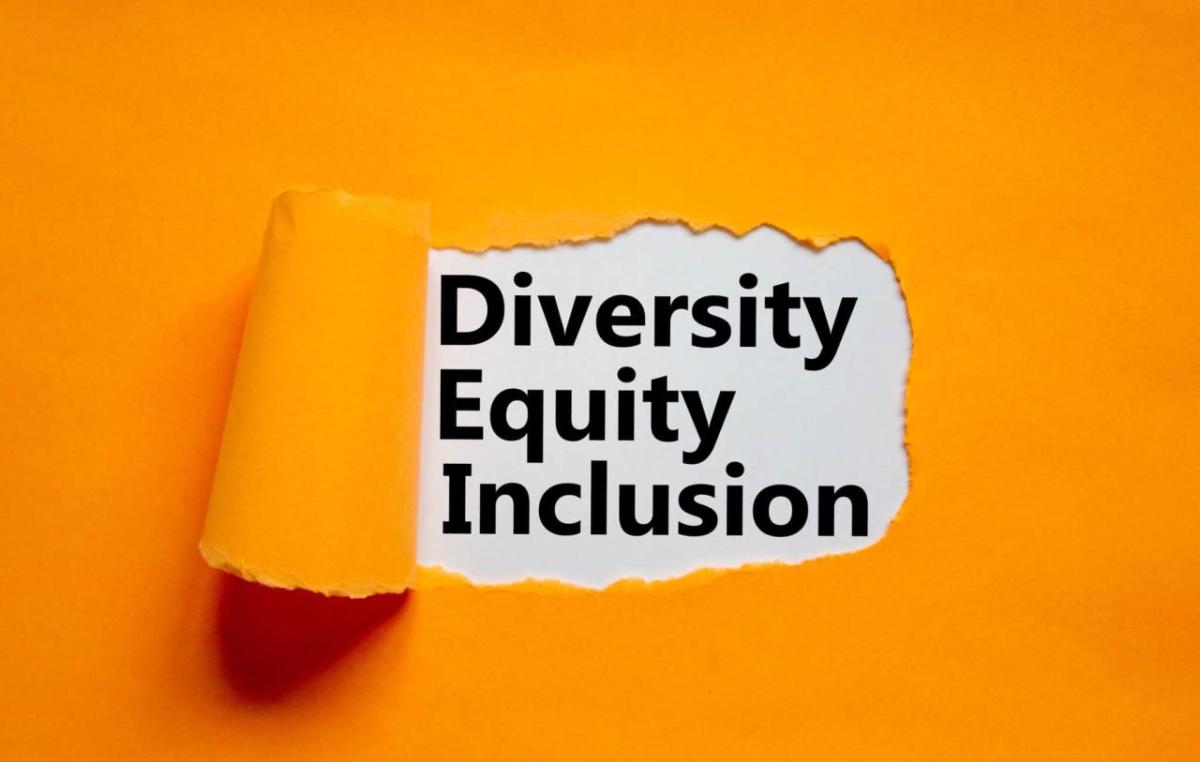 Image courtesy of Mergers & Acquisitions piece of orange paper pealed back in the middle, revealing text that reads "diversity equity inclusion"