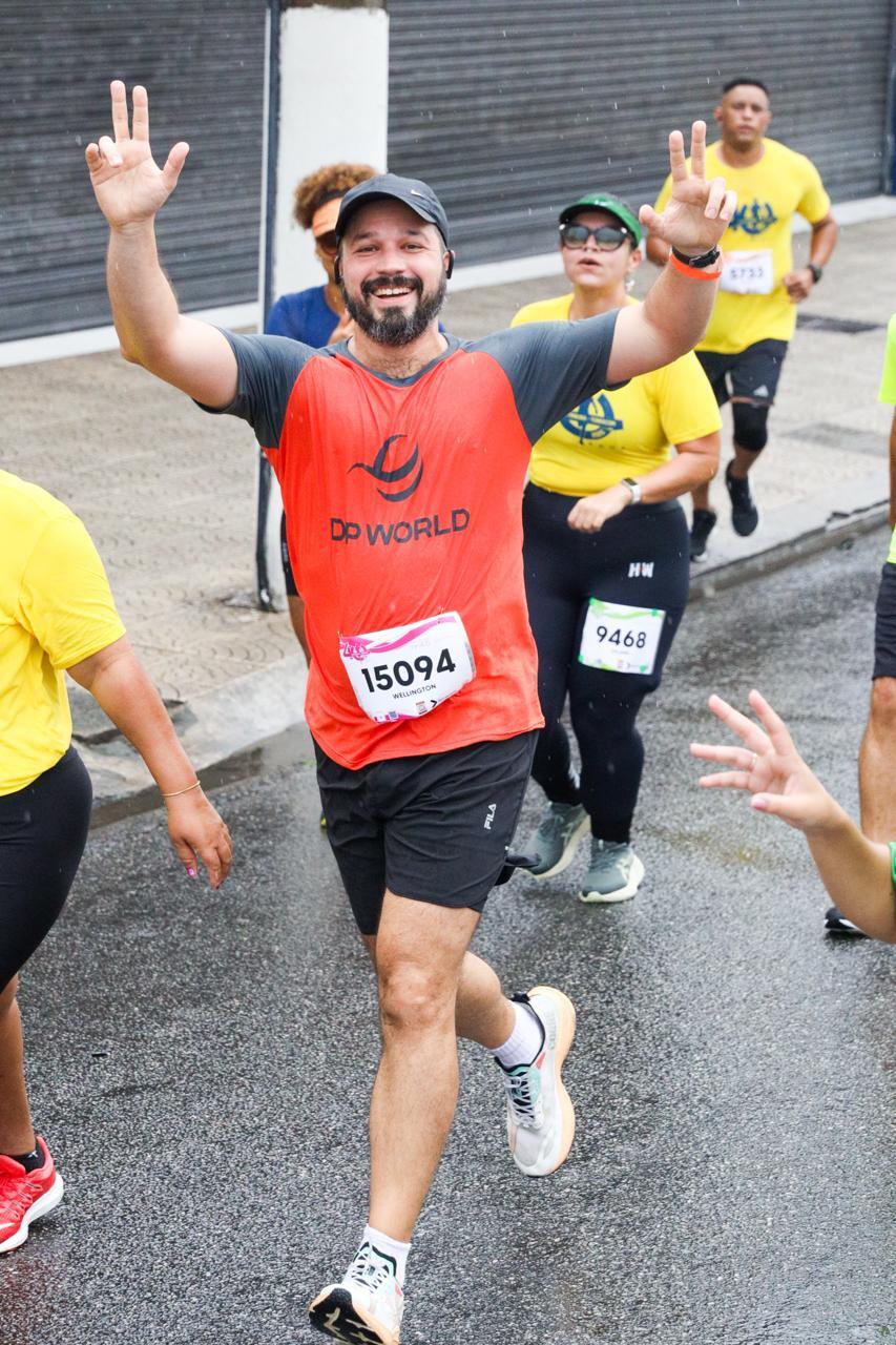 A DP World employee waves while running during the 40th edition of the 10KM Tribuna FM Race in Santos, Brazil.