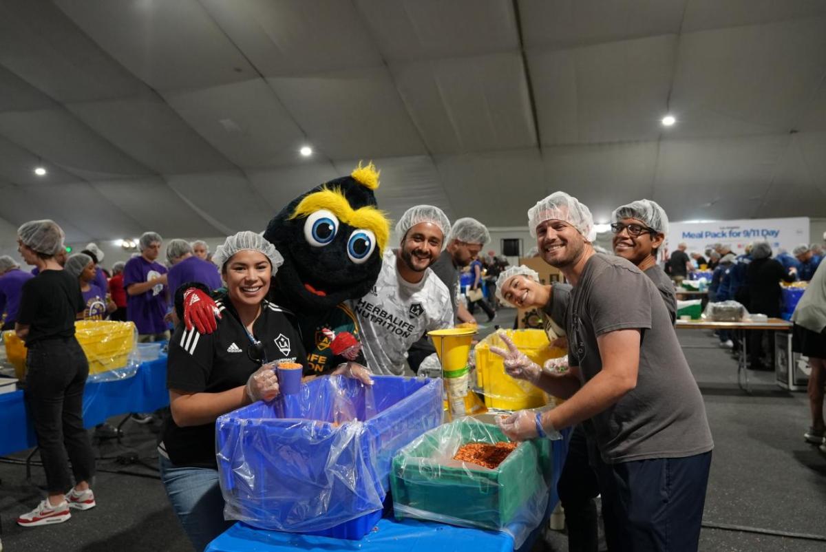 LA Galaxy's mascot Cozmo helps pack meals with volunteers from LA Galaxy.