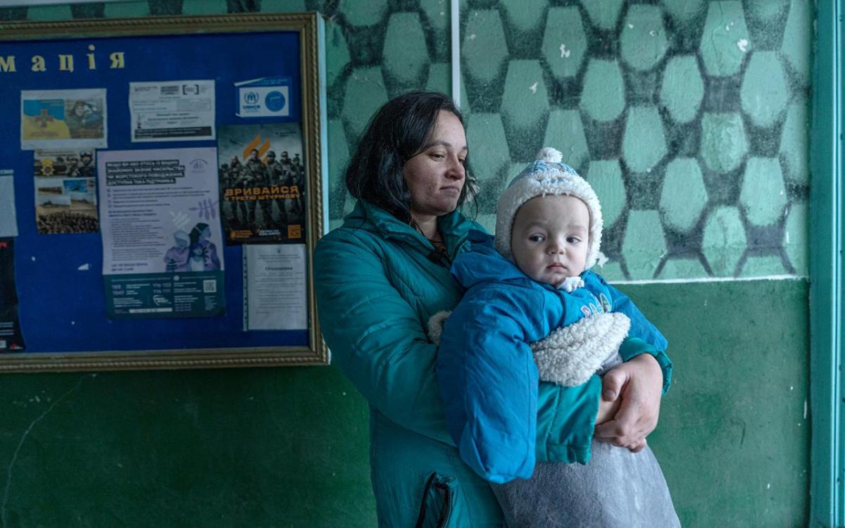 Photo by Anton Shynkarenko, January 2025 Woman holds baby in clinic with teal walls