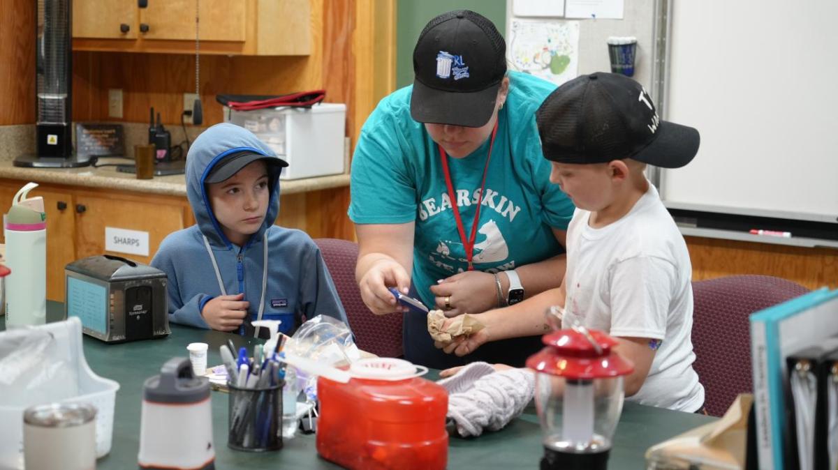A camp staff member at Bearskin Meadows Camp, a camp for children living with Type 1 diabetes, helps young campers measure their blood glucose levels. The camp has received donated diabetes management products from embecta via Direct Relief. (Kim Ofilas/Direct Relief)