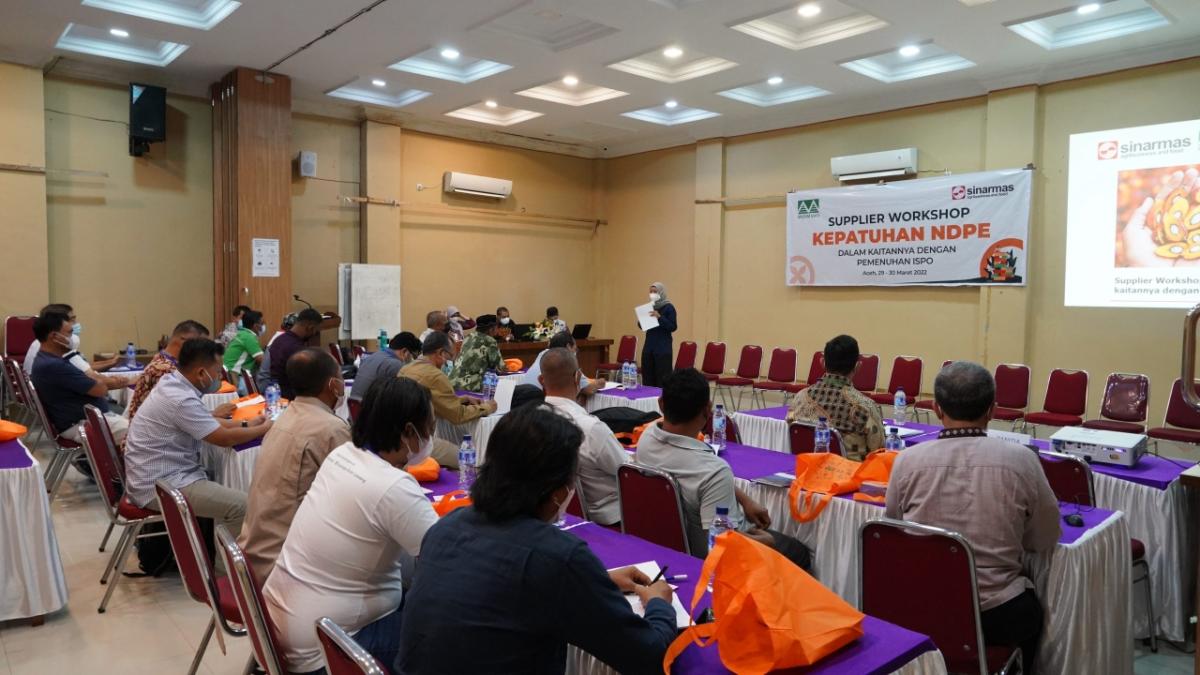 Person speaking at an event with people sitting at tables