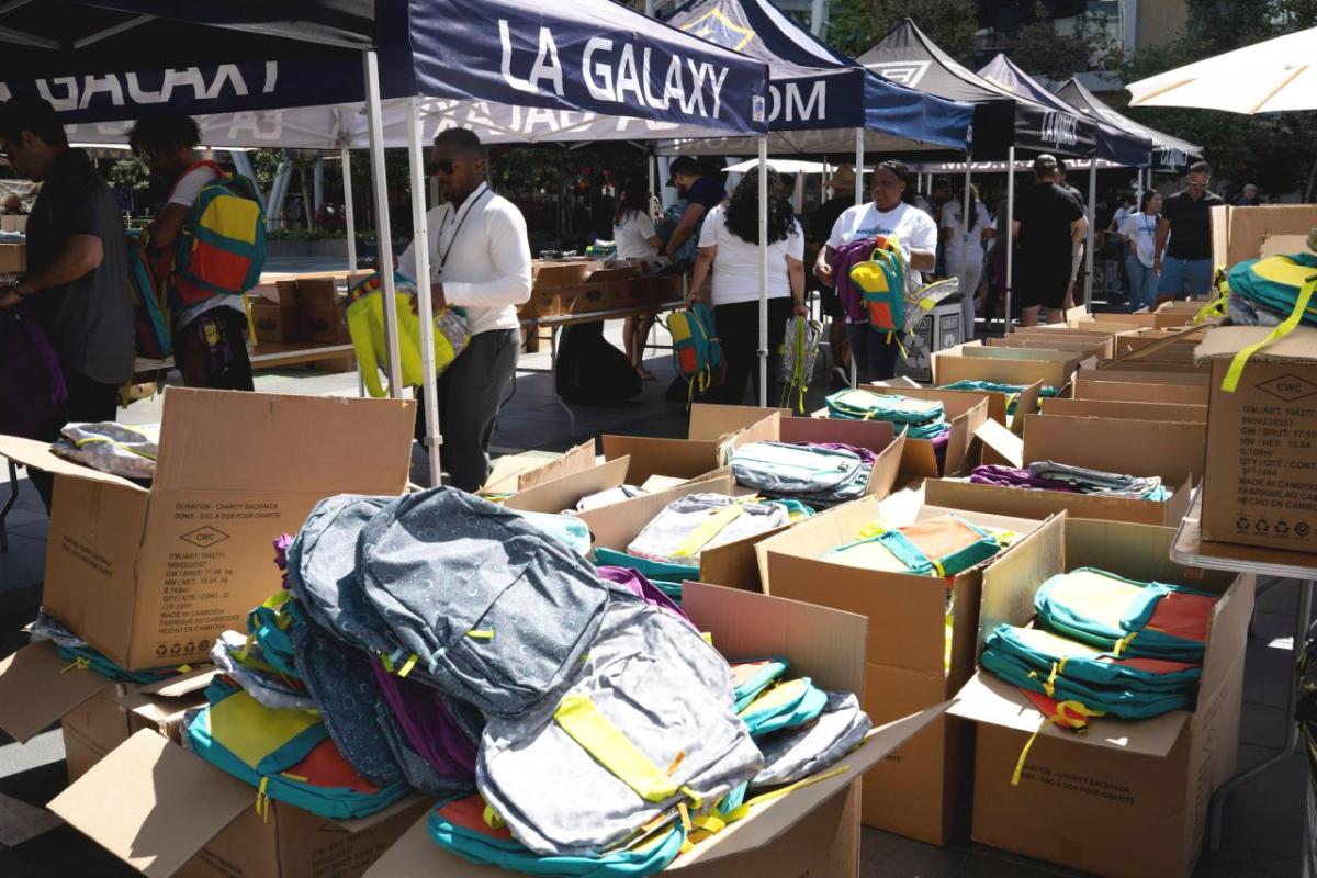 Employees from AEG, LA Galaxy and LA Kings help pack backpacks for under-resourced students at their school supplies drive.