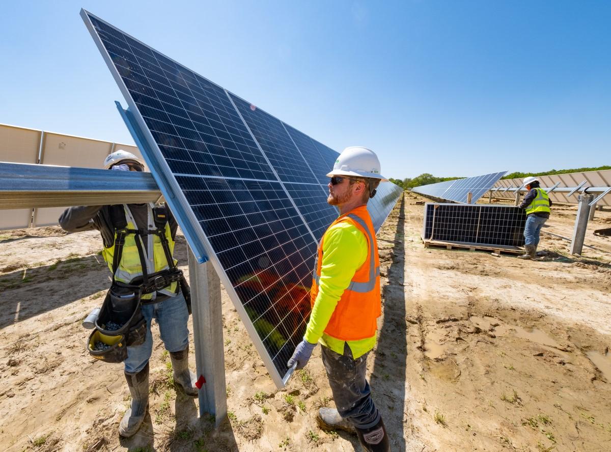 two men working on solar panels
