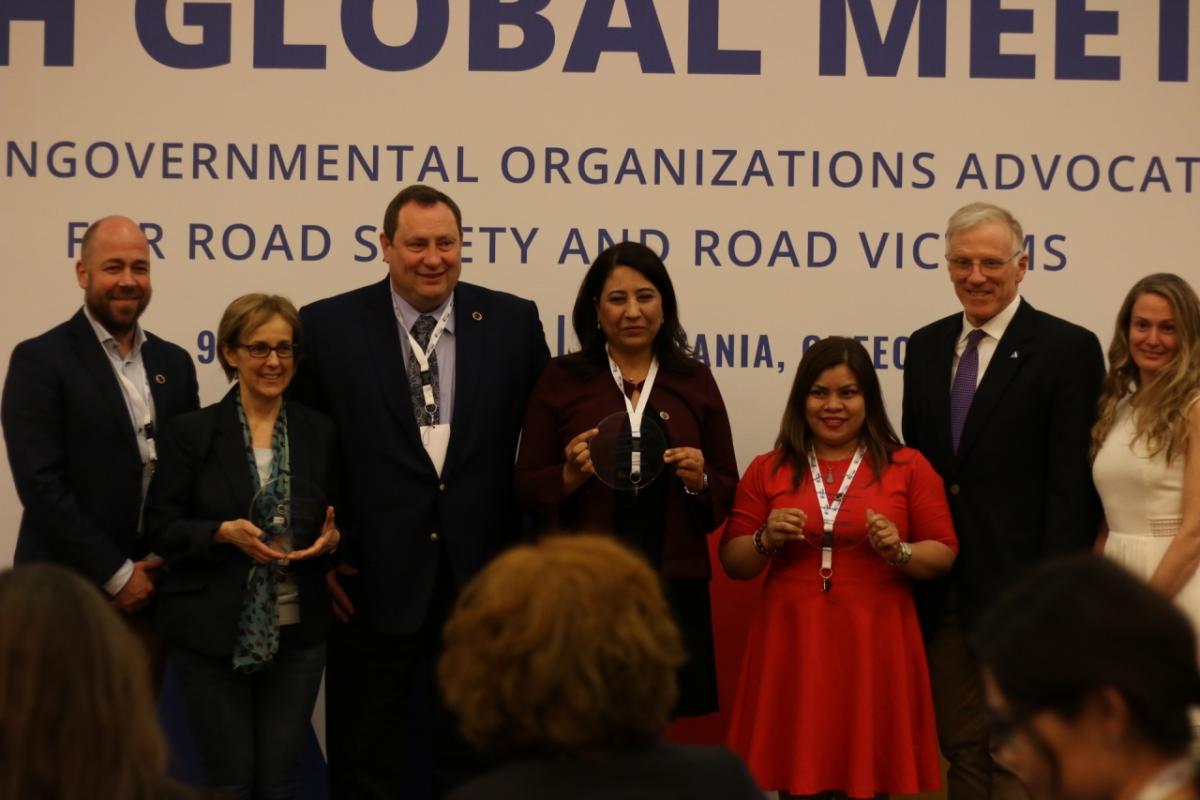 A group of people posing for a folder with 3 holding awards