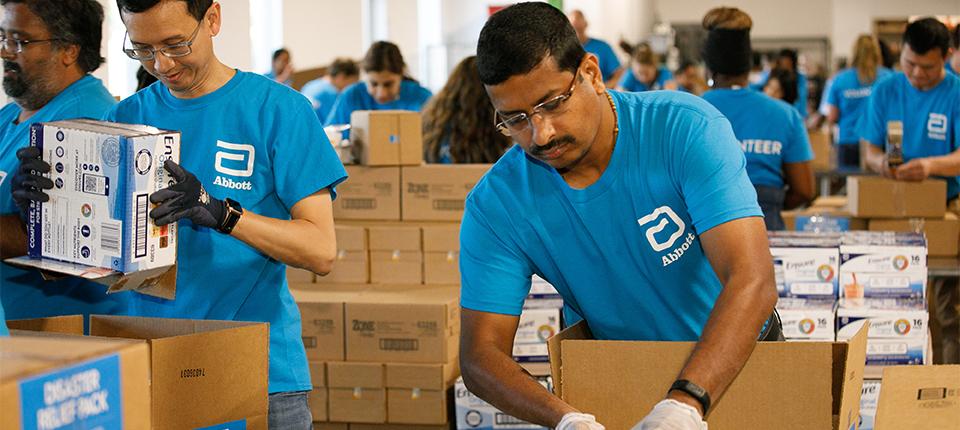 people in aqua abbott t-shirts packing boxes