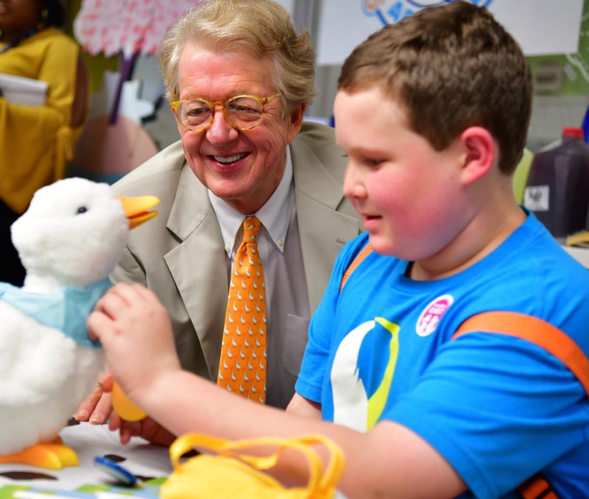 Aflac CEO Dan Amos admires the My Special Aflac Duck along with his friend, Ethan Daniels, 13, at the Aflac Cancer Center in Atlanta