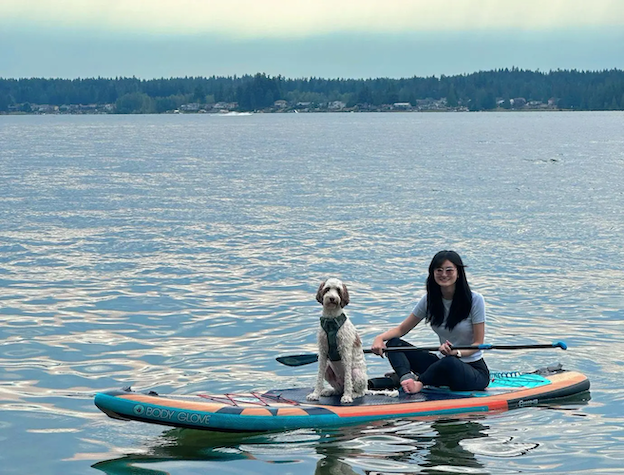 Dannie and her dog on a paddle board.