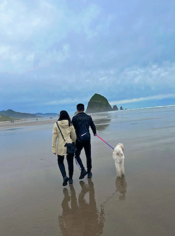 Dannie and another person walking her dog on a beach.