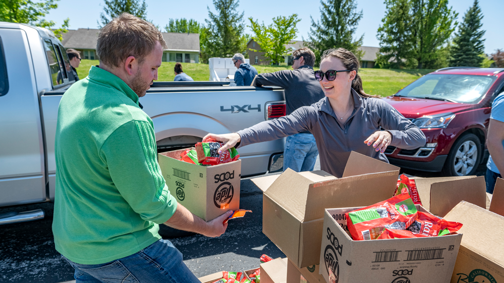 Volunteer passing out box filled with food