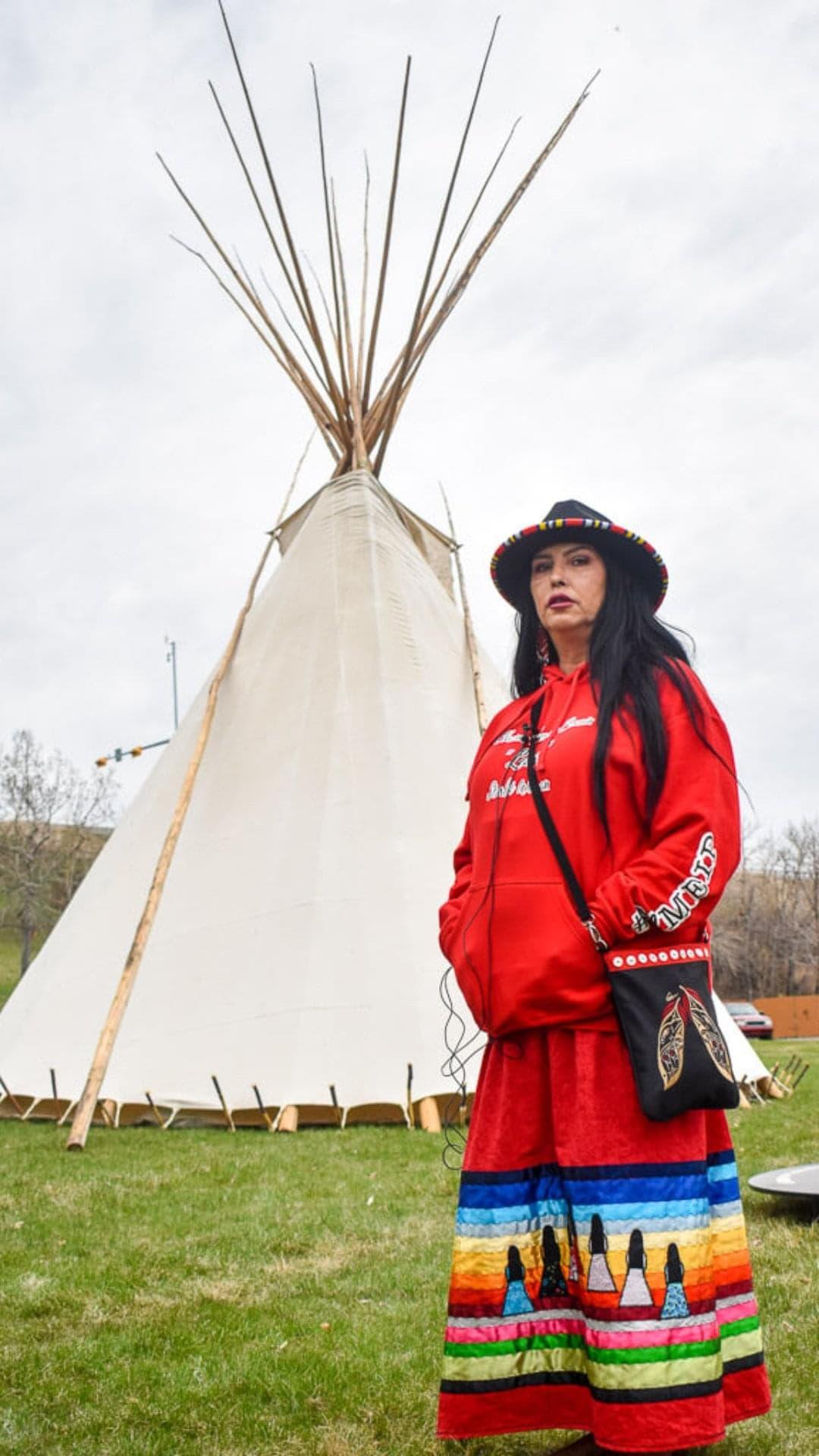 Deborah in traditional costume, a teepee behind her.