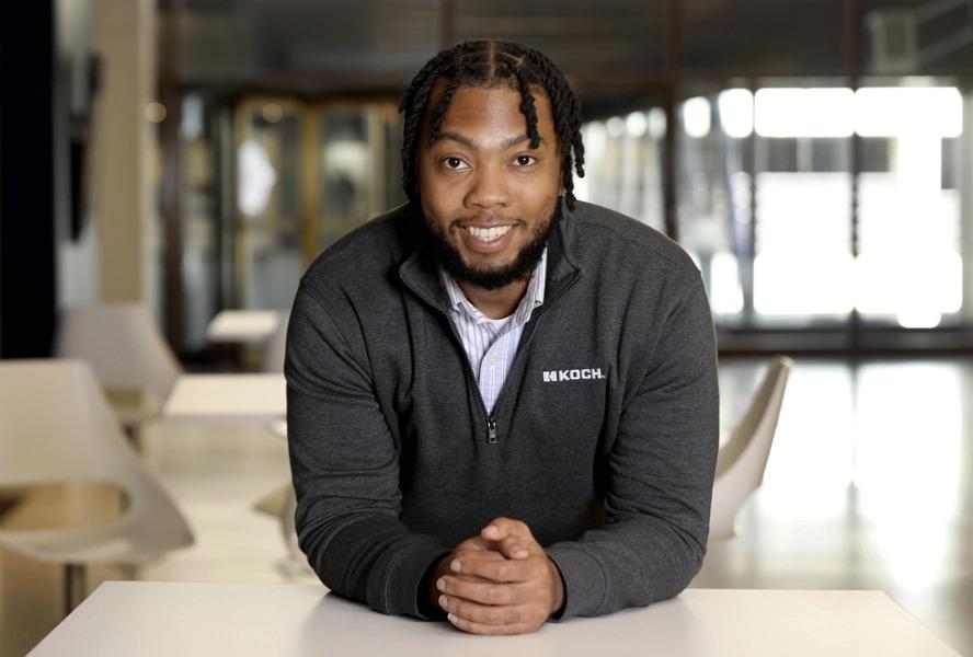 Demarcus Reaves leaning on a desk smiling