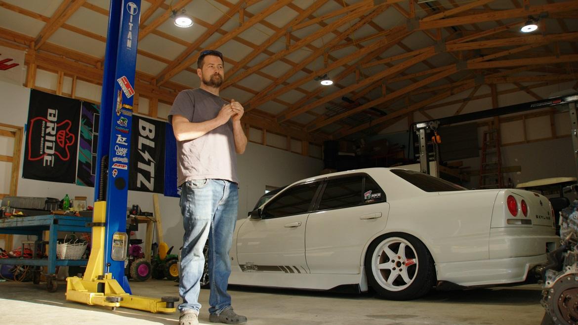 Jacob standing next to white car