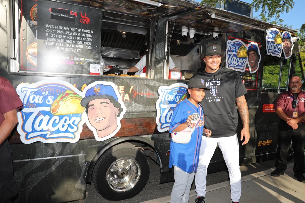 Kid and adult posing in front of Tai's Taco Truck