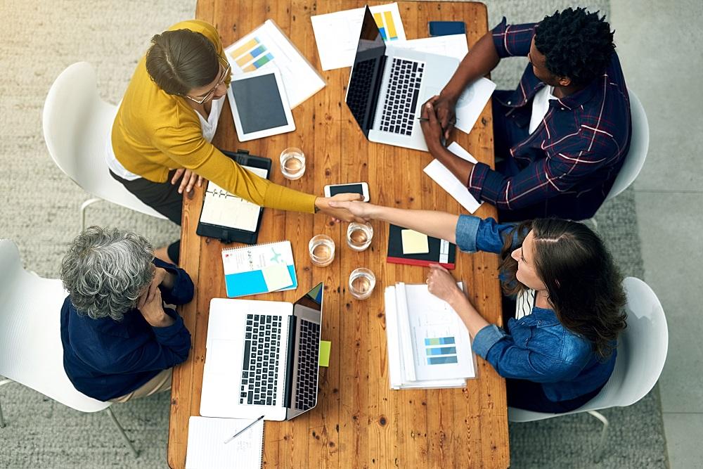 group of people working on laptops, viewed from above