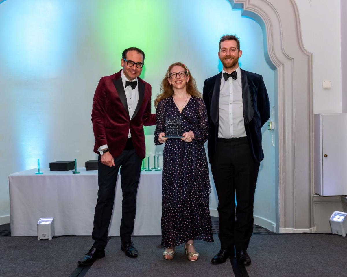 Three people holding an award