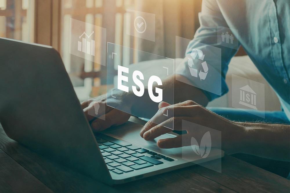 Person typing on laptop with ESG floating above