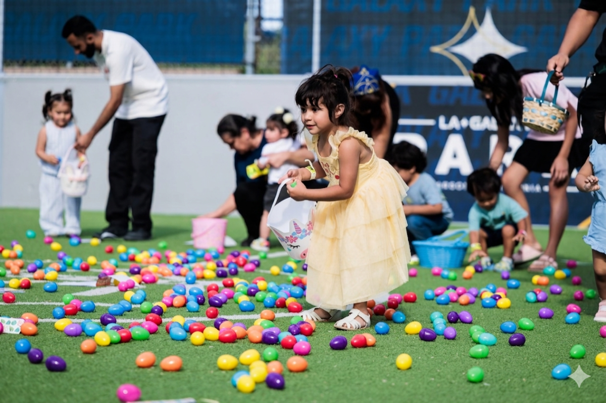 Children collect colorful plastic eggs scattered across an artificial turf field during a community celebration.