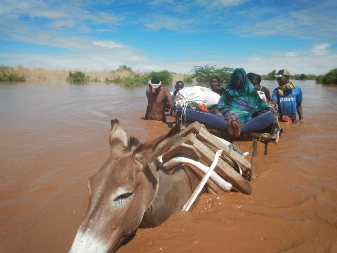 Elderly women travel through the floods via donkey.