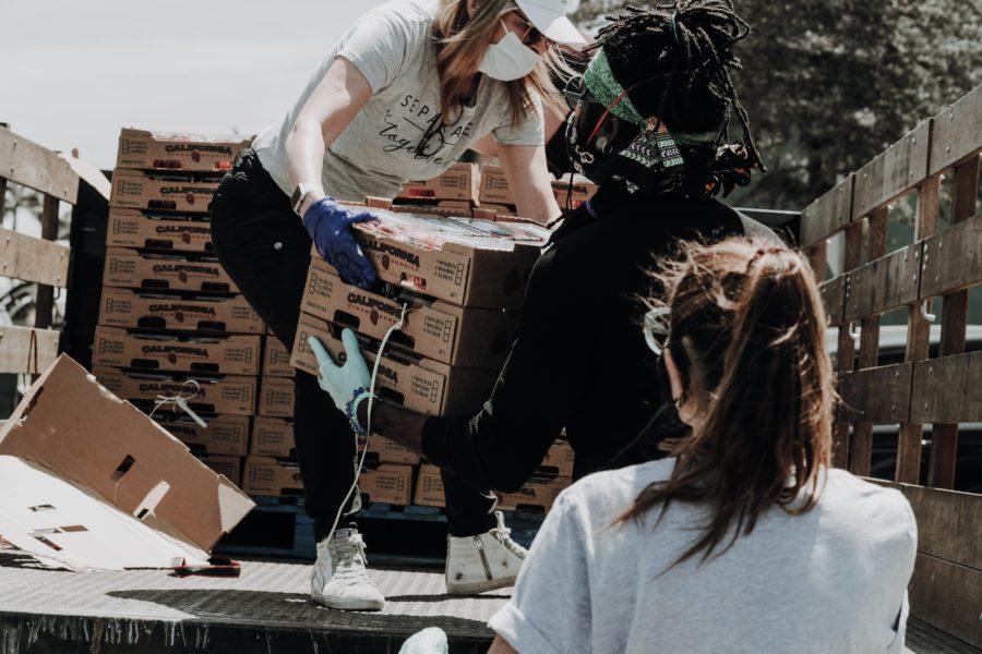 volunteer passing boxes off a truck 