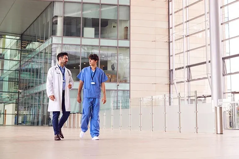 a doctor and nurse walk out of a hospital