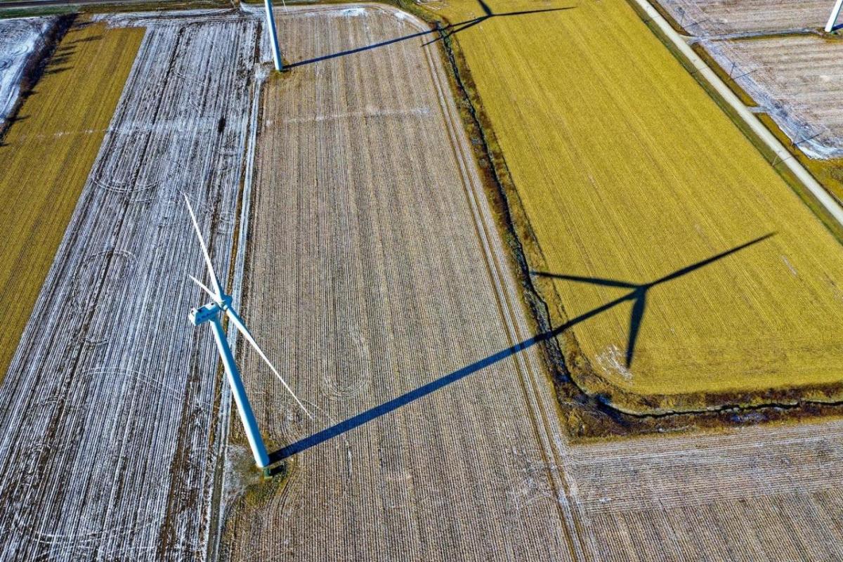 Aerial view of farms with wind turbines and a country road