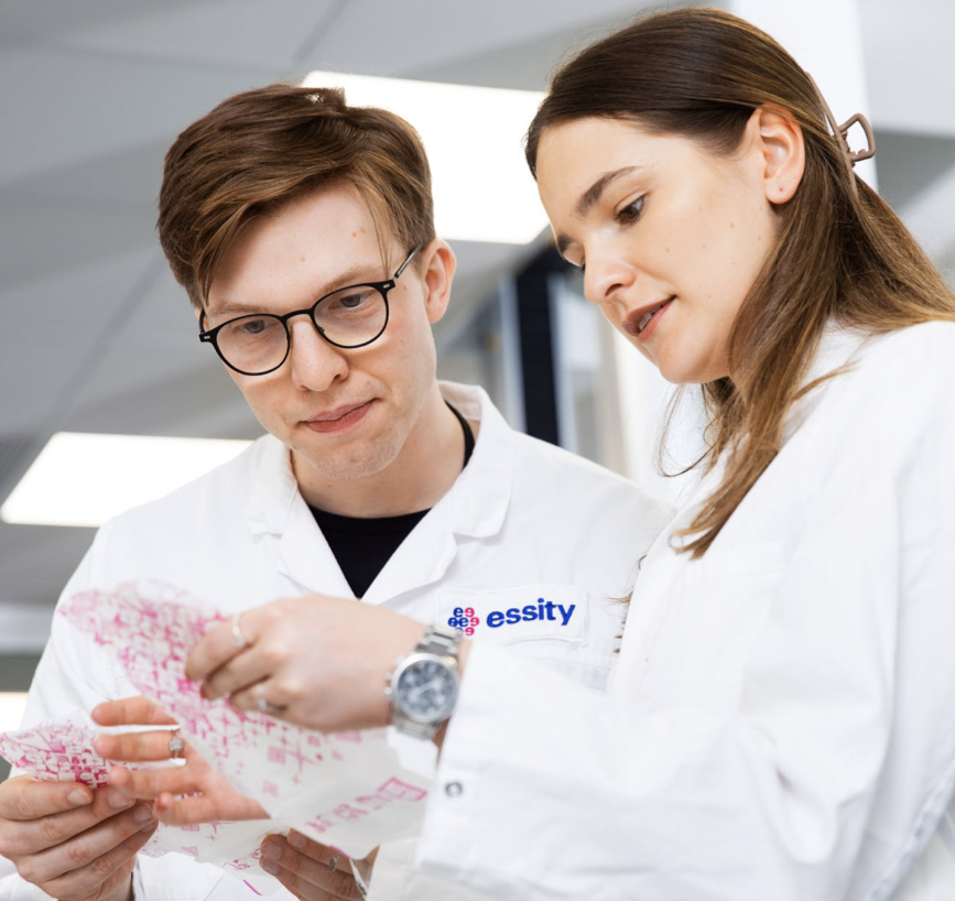 A female and a male technician are looking at a report.