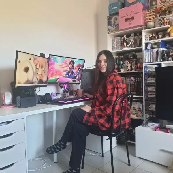 person sitting at desk with monitors showing video games