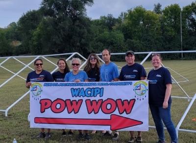 Employees holding a wacipi pow-wow banner