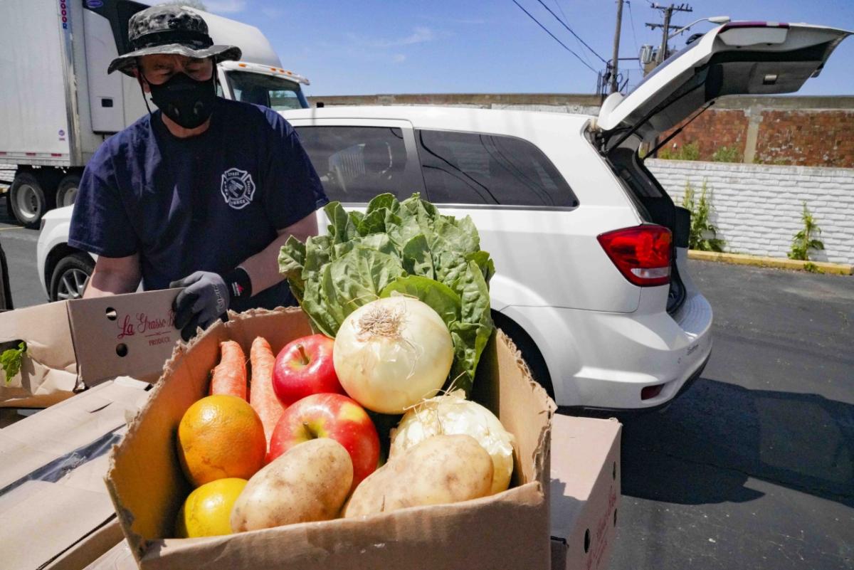 Fresh produce is distributed to the communities that need it most via the MealConnect platform person with a box of fresh produce