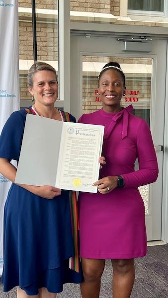 Dutchess County Mental Health Commissioner Jean-Marie Niehbur (left) presents a proclamation on half of County Executive Sue Serino’s office to KeyBank’s Senior Area Retail Leader Irenee Provenzano.