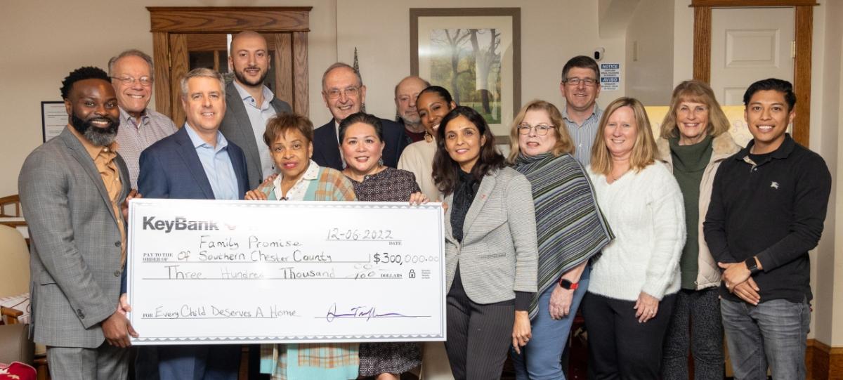 Group of people hold a large KeyBank check