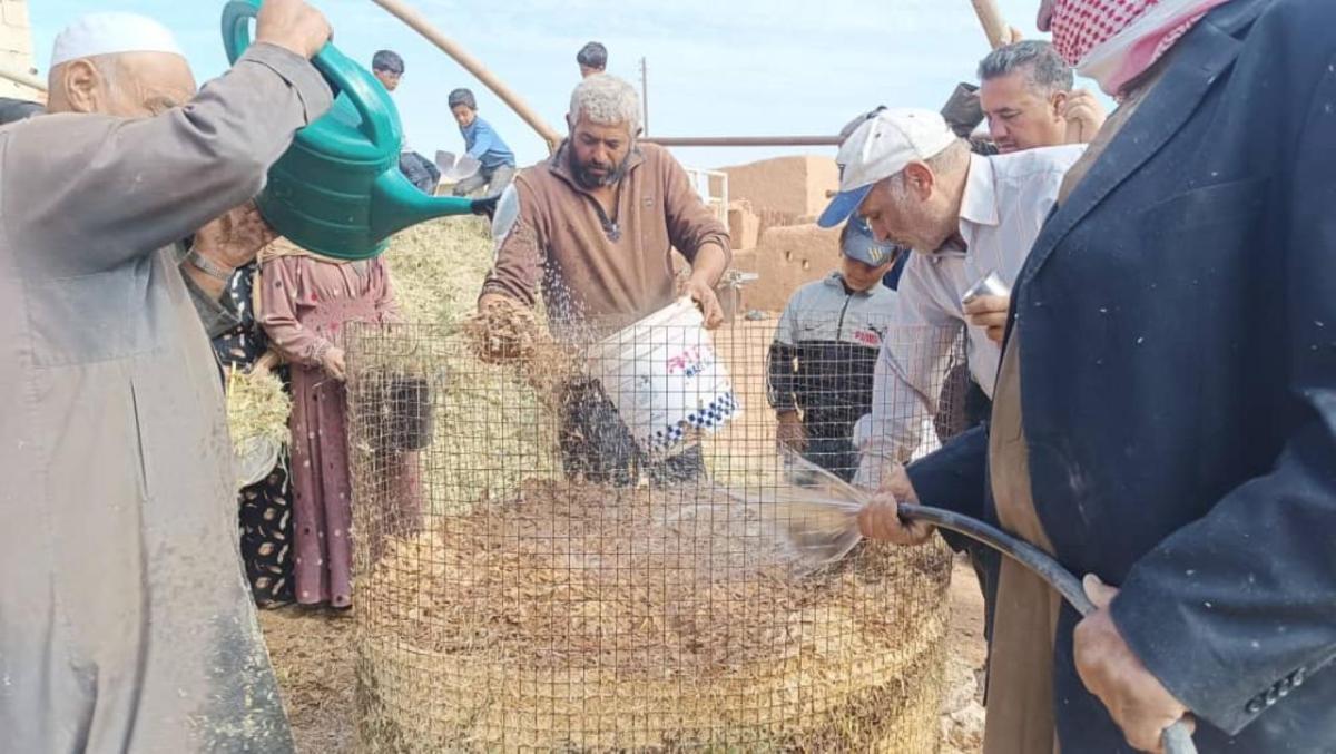 Ibrahim (center) and other farmers learn to make compost.