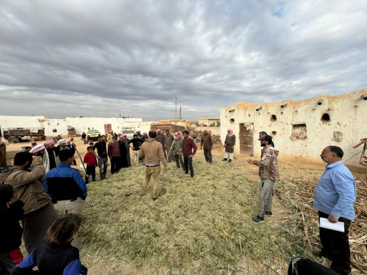 Farmers gather outside of Ibrahim’s home for Farm Field School.