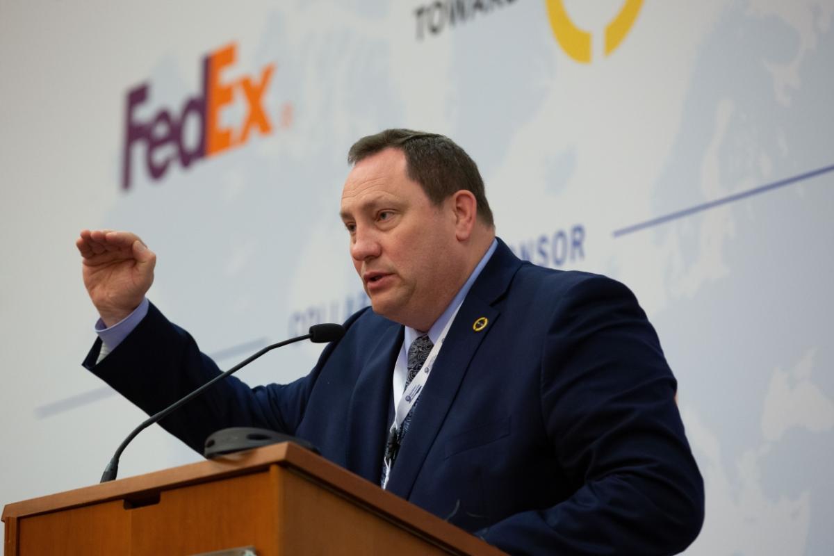 A man in a suit talking at a podium