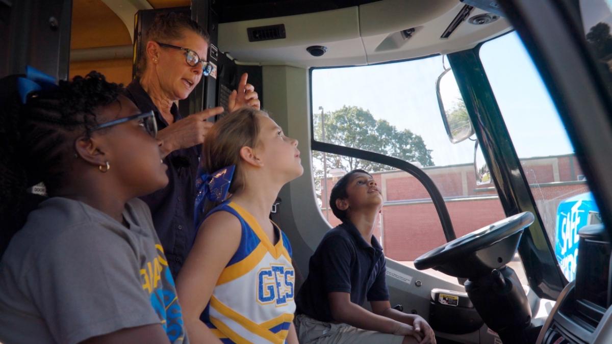 4 people sitting in the front seats of a van