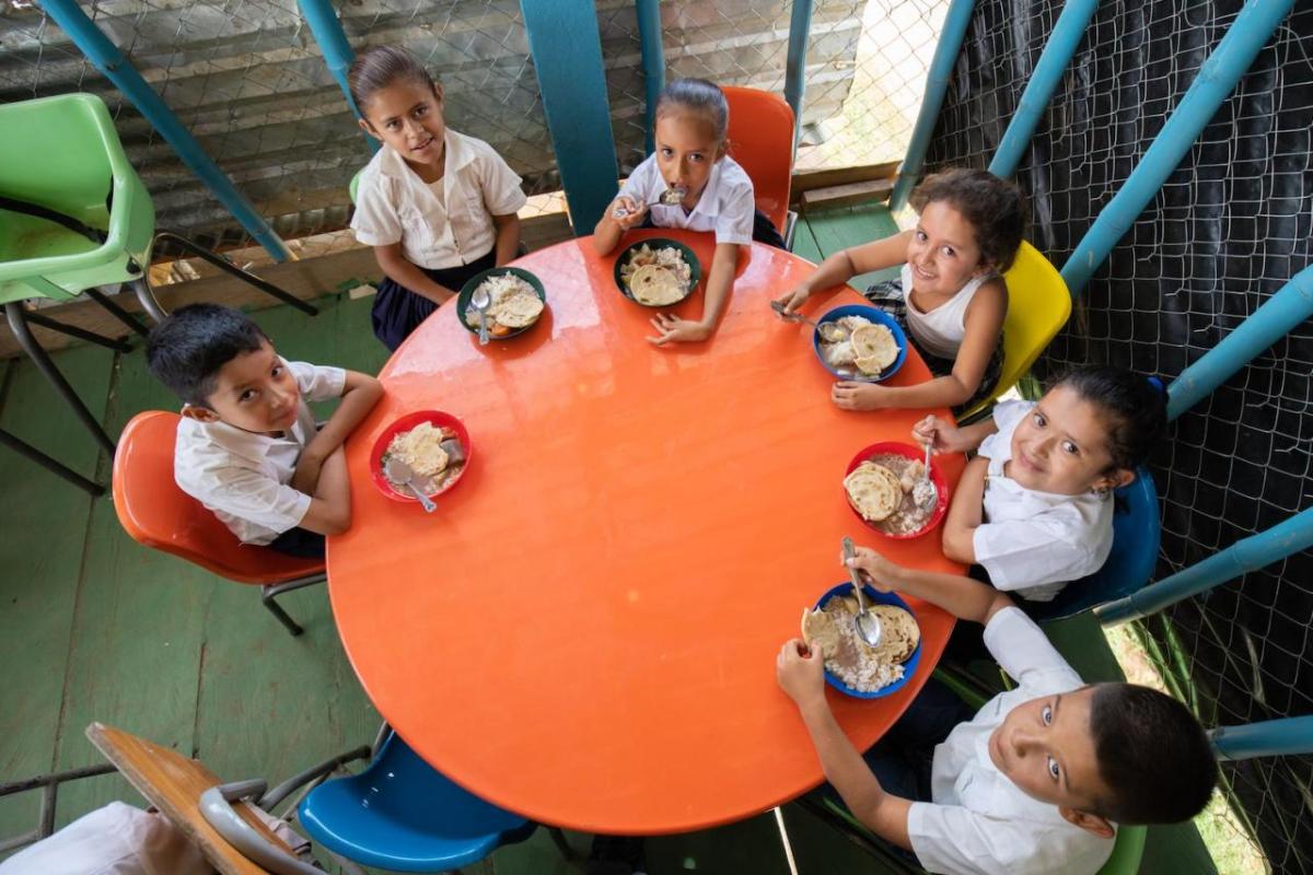 Children eating at small round table together