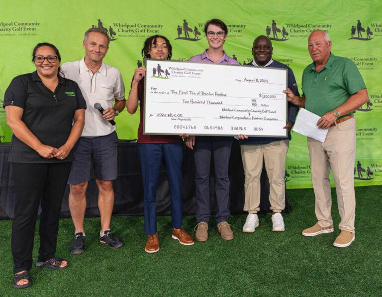 Representatives from First Tee of Benton Harbor pose with a large check